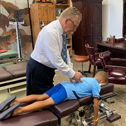 Dr. Toth giving a gentle adjustment to a young patient on the table
