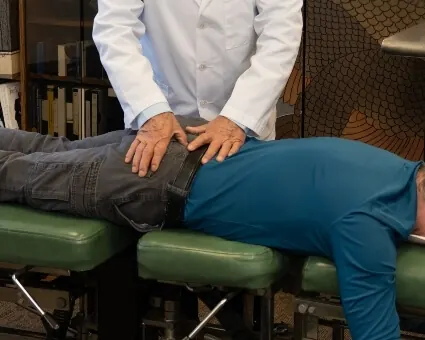 Dr. Toth applying gentle pressure to a patient's lower back during treatment