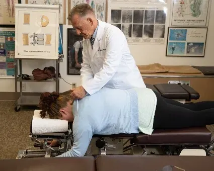 Dr. Toth making an Activator adjustment to a patient's neck