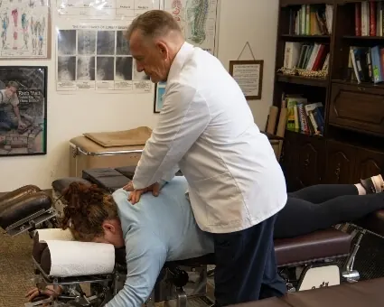 Dr. Toth adjusting a patient's upper back on the treatment table